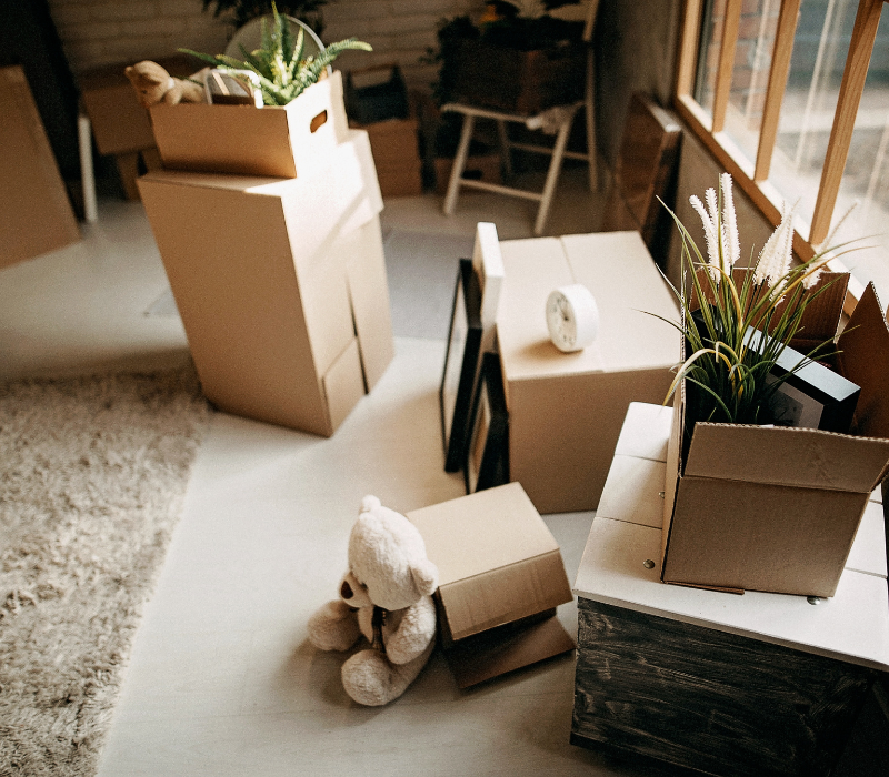 Moving boxes labeled and packed for employee relocation, ready for transport to new employee residences